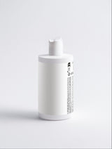 White bottle with a pump on a light gray background